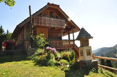 a log cabin with flowers in front of it at Chalets Toplak in Sveti Duh na Ostrem Vrhu