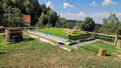 a field with a green field with a statue of a bird at Chalets Toplak in Sveti Duh na Ostrem Vrhu