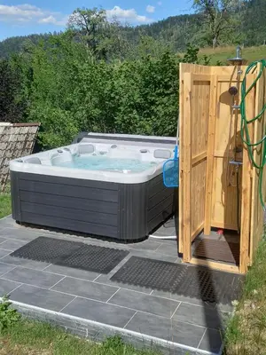 a jacuzzi tub with a wooden door at B&B family room Tubej in Bohinj
