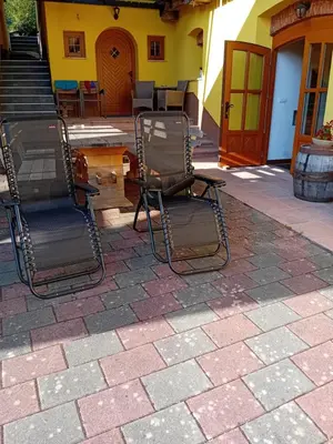 two chairs sitting on a patio in front of a house at B&B family room Tubej in Bohinj