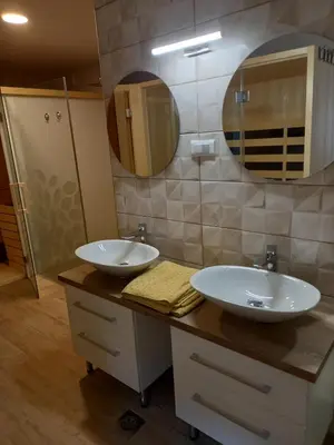 a bathroom with two sinks and a mirror at SPA Tubej - Adults Only in Bohinj