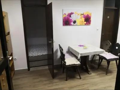 a table and chairs in a room with a painting on the wall at Apartman Alja, Kranjska Gora in Kranjska Gora