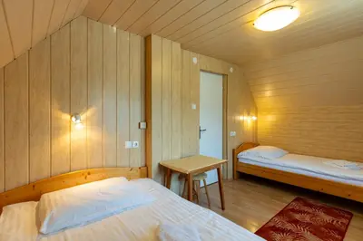 a room with two beds and a table in it at Apartma Boltar in Bohinj