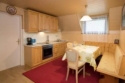 a kitchen with a table and a table and chairs at Apartma Boltar in Bohinj