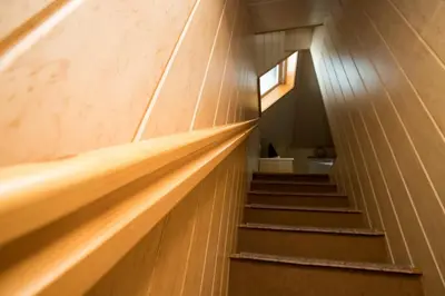 a stairway leading up to a room with wooden walls at Apartma Boltar in Bohinj