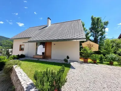 a small white house with a roof at Apartma Hiša 6 in Bohinj