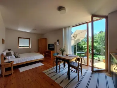 a bedroom with a bed and a desk with a table at Apartma Hiša 6 in Bohinj