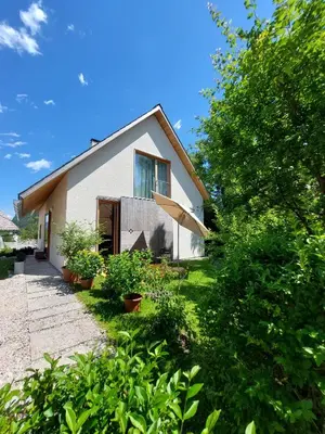 a small white house with a tree in front of it at Apartma Hiša 6 in Bohinj