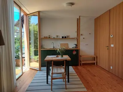 a kitchen with a table with chairs and a kitchen with sliding glass doors at Apartma Hiša 6 in Bohinj