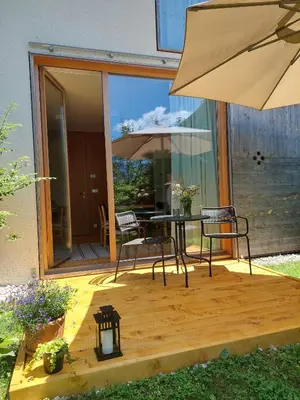 a patio with a table and chairs and an umbrella at Apartma Hiša 6 in Bohinj
