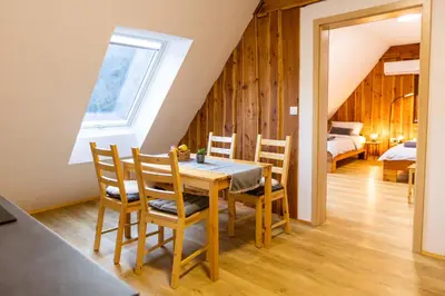 a dining room with a table and chairs and a bedroom at Apartmaji pri Dravi in Podvelka