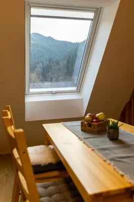 a table with a window and a basket of fruit at Apartmaji pri Dravi in Podvelka