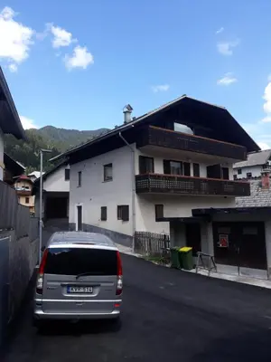 a van parked in a parking lot in front of a house at APARTMA 27 in Kranjska Gora