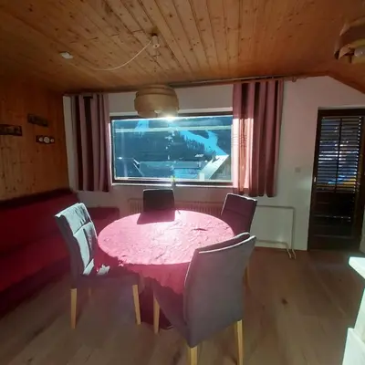 a pink table and chairs in a room with a window at APARTMA 27 in Kranjska Gora