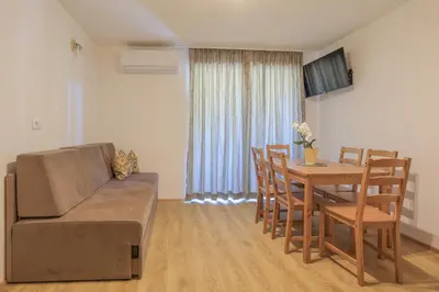 a living room with a couch and a dining room table at Apartments Mulej in Bled