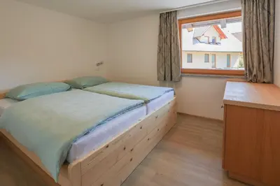 a bedroom with a large bed with a window at Apartments Mulej in Bled