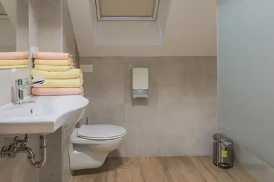 a bathroom with a toilet and a sink and towels at Apartments Mulej in Bled