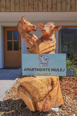 a statue of two dogs hugging a log at Apartments Mulej in Bled