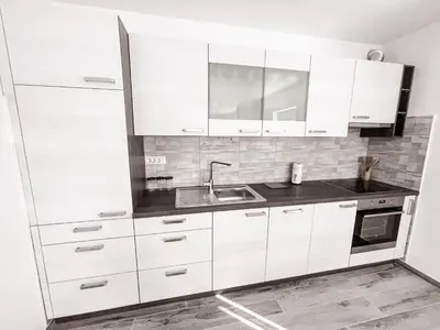 a kitchen with white cabinets and a sink at RIAD Apartments Premium in Zgornje Škofije