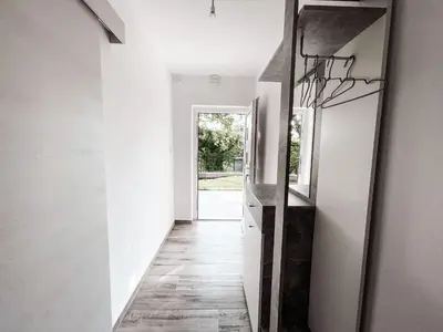 a hallway of a house with white walls and a mirror at RIAD Apartments Premium in Zgornje Škofije