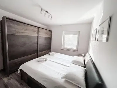 a bedroom with a large bed with white sheets at RIAD Apartments Premium in Zgornje Škofije