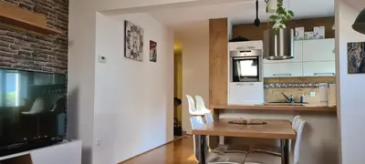 a kitchen with a table and chairs and a tv at Rozmarin Bled in Bled