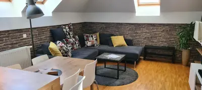 a living room with a couch and a brick wall at Rozmarin Bled in Bled