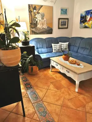 a living room with a blue couch and a coffee table at Apartmaji ARKO in Ribnica
