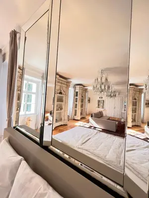 a bedroom with a large mirror on the wall at AB Ljubljana - Breg Apartments in Ljubljana