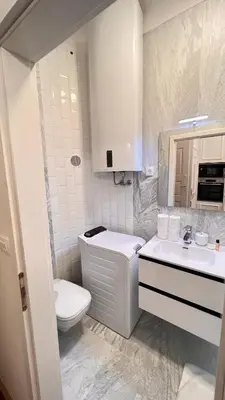 a white bathroom with a toilet and a sink at AB Ljubljana - Breg Apartments in Ljubljana