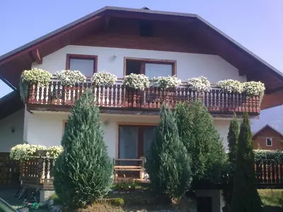 a house with a balcony with plants on it at Apartmaji Sparakel in Bled