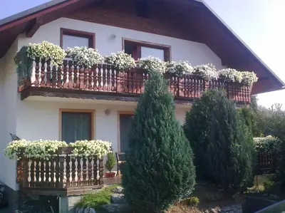 a house with a balcony with potted plants on it at Apartmaji Sparakel in Bled