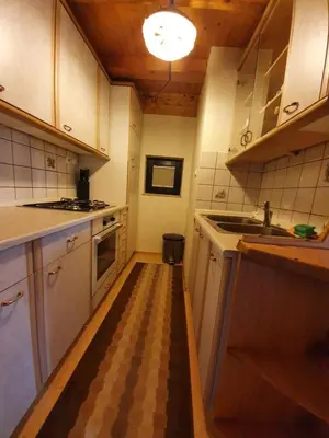 a kitchen with white cabinets and a checkered floor at Chalet Anita Rogla in Zreče