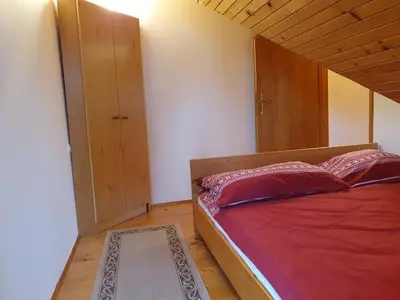 a bedroom with a red bed and a closet at Chalet Anita Rogla in Zreče