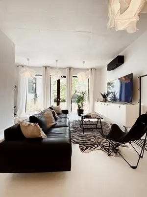 a living room with a black couch and a table at Villa Pomona in Bled