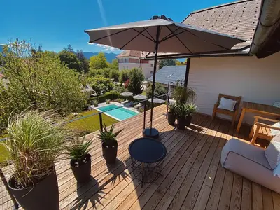 a wooden deck with an umbrella and potted plants at Villa Pomona in Bled