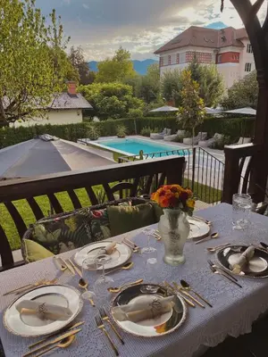 a table with plates and utensils on a table with a pool at Villa Pomona in Bled