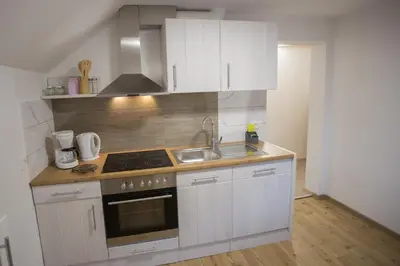 a kitchen with white cabinets and a stove and a sink at APARTMAJI HUBI in Bled