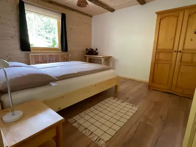a bedroom with a large bed and a window at Apartma Korošec in Srednja Vas v Bohinju