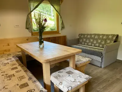 a living room with a table and a couch at Apartma Korošec in Srednja Vas v Bohinju
