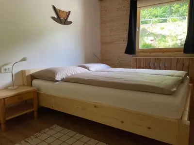 a bed in a bedroom with a window at Apartma Korošec in Srednja Vas v Bohinju