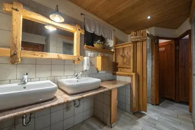 a bathroom with two sinks and a mirror at Tonkina koča in Kranjska Gora