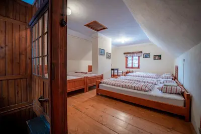 a bedroom with two beds and a wooden floor at Tonkina koča in Kranjska Gora