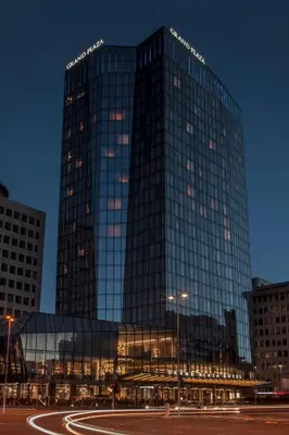 a tall glass building with a street in front of it at Grand Plaza Hotel & Congress Center in Ljubljana