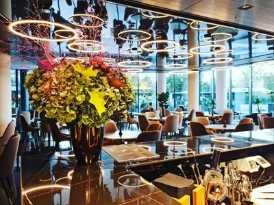 a vase of flowers on a table in a restaurant at Grand Plaza Hotel & Congress Center in Ljubljana