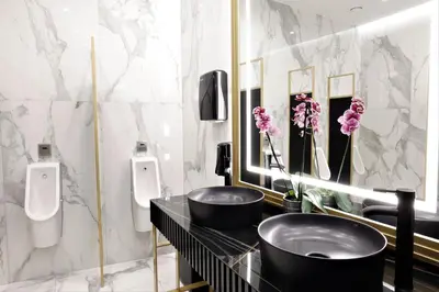 a bathroom with two sinks and two urinals at Grand Plaza Hotel & Congress Center in Ljubljana