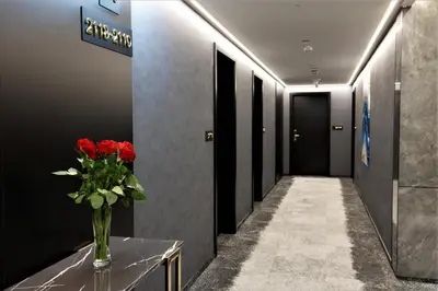 a hallway with a vase of red flowers on a table at Grand Plaza Hotel & Congress Center in Ljubljana