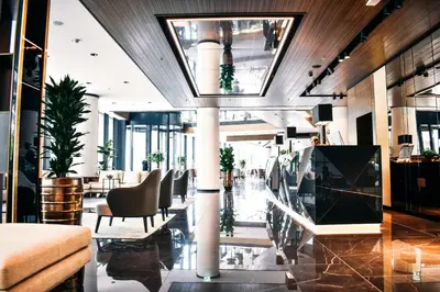 a lobby of a hotel with chairs and tables at Grand Plaza Hotel & Congress Center in Ljubljana