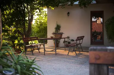 a patio with a table and chairs in front of a house at Apartma Pic Ros in Kojsko