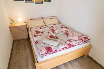 a bed with a quilt on it in a room at Apartma pri lipi in Bohinj